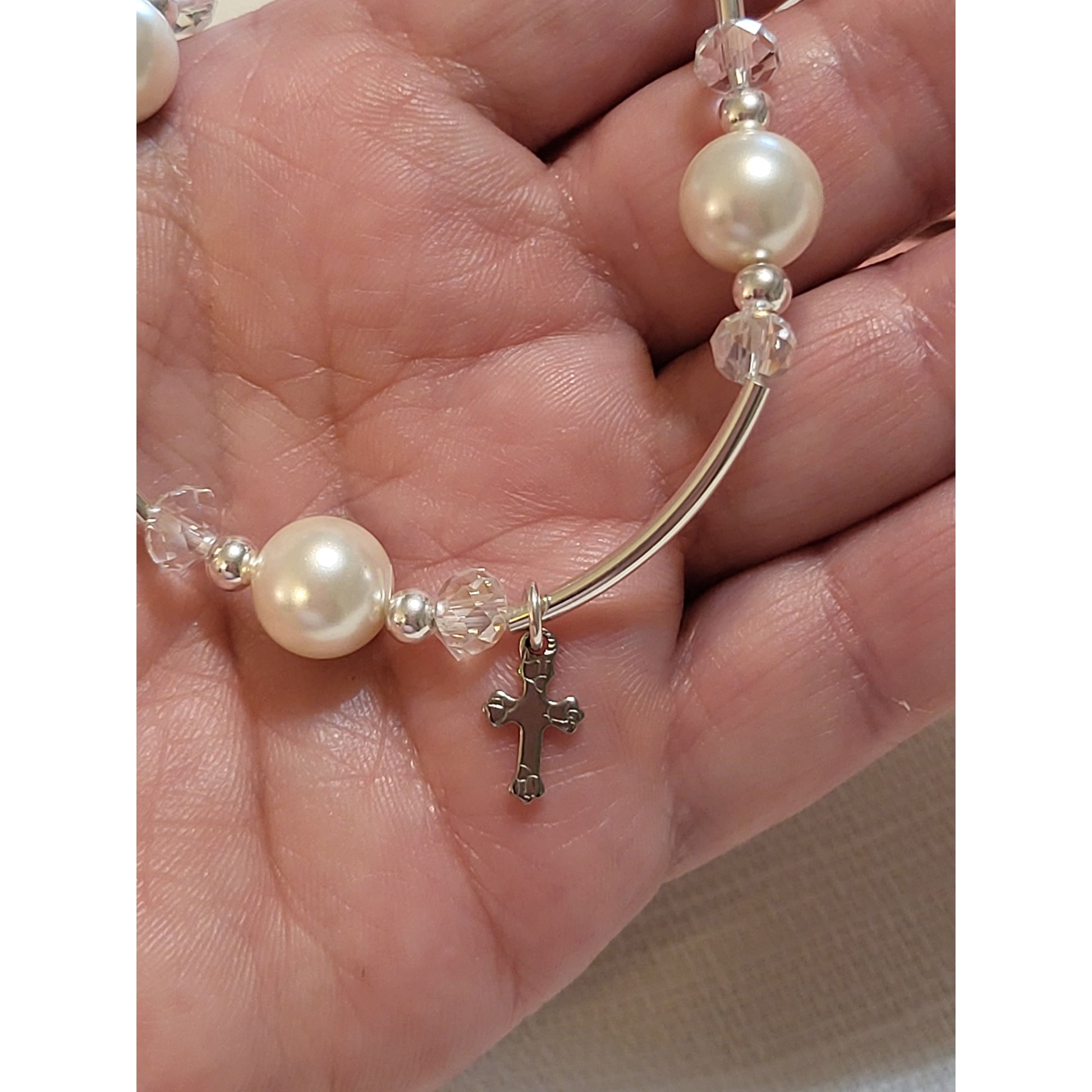 The tiny Stainless Steel cross is hand stamped on each corner with a design making each cross unique.